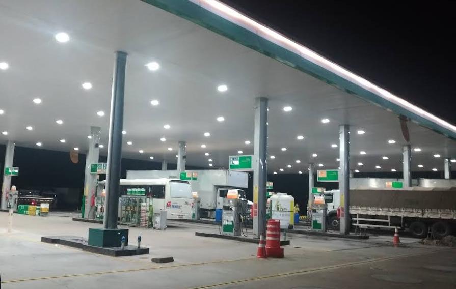 Bombas e veículos na pista de abastecimento à noite
