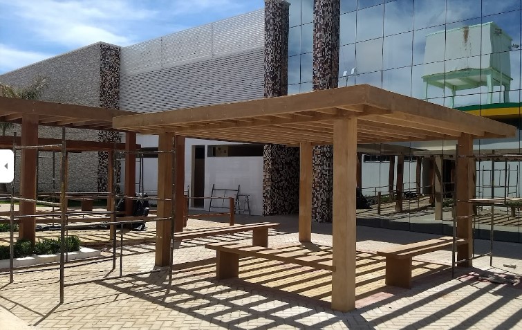 Praça externa com bancos e pergolados