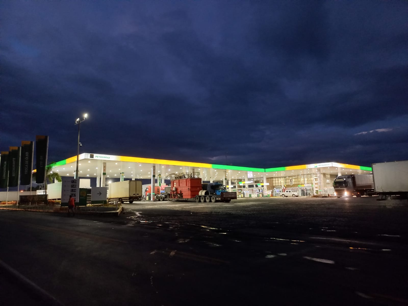 Posto com testeira iluminada sob o céu noturno